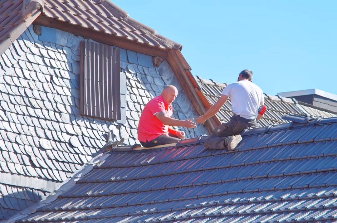 professional roofing crew installing new shingles on a residential roof professional roofing crew installing new shingles on a residential roof