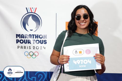 Coach Sofia holding her runners number in Paris for the 10k