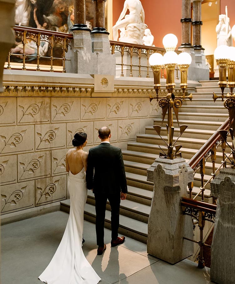 Bride and groom walking up a staircase during a wedding planned by Porch & Pearls