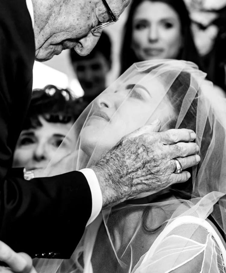 Emotional moment between bride and her grandfather during a heartfelt wedding ceremony planned by Porch & Pearls
