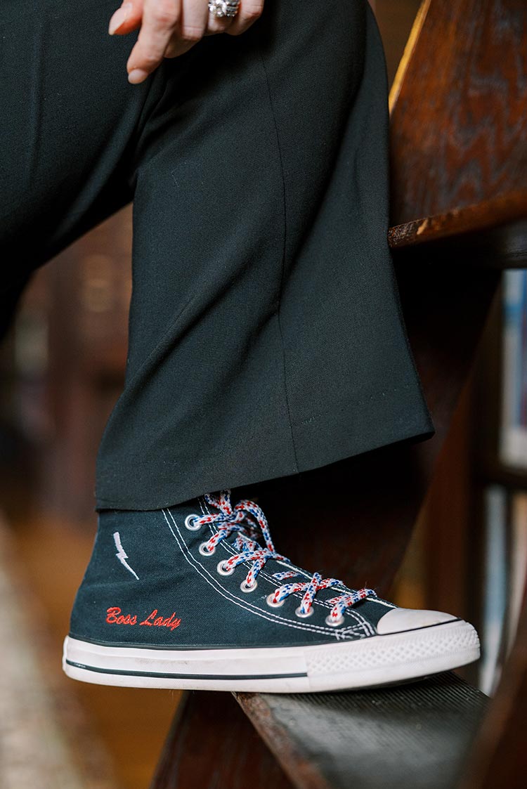 Close up of Marian Braccia's sneaker that says 'boss lady' in red writing
