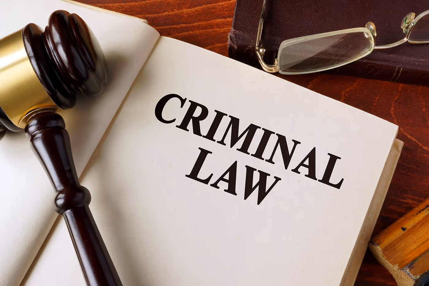picture of an open book with the words Criminal Law written on the page, a gavel lays on top