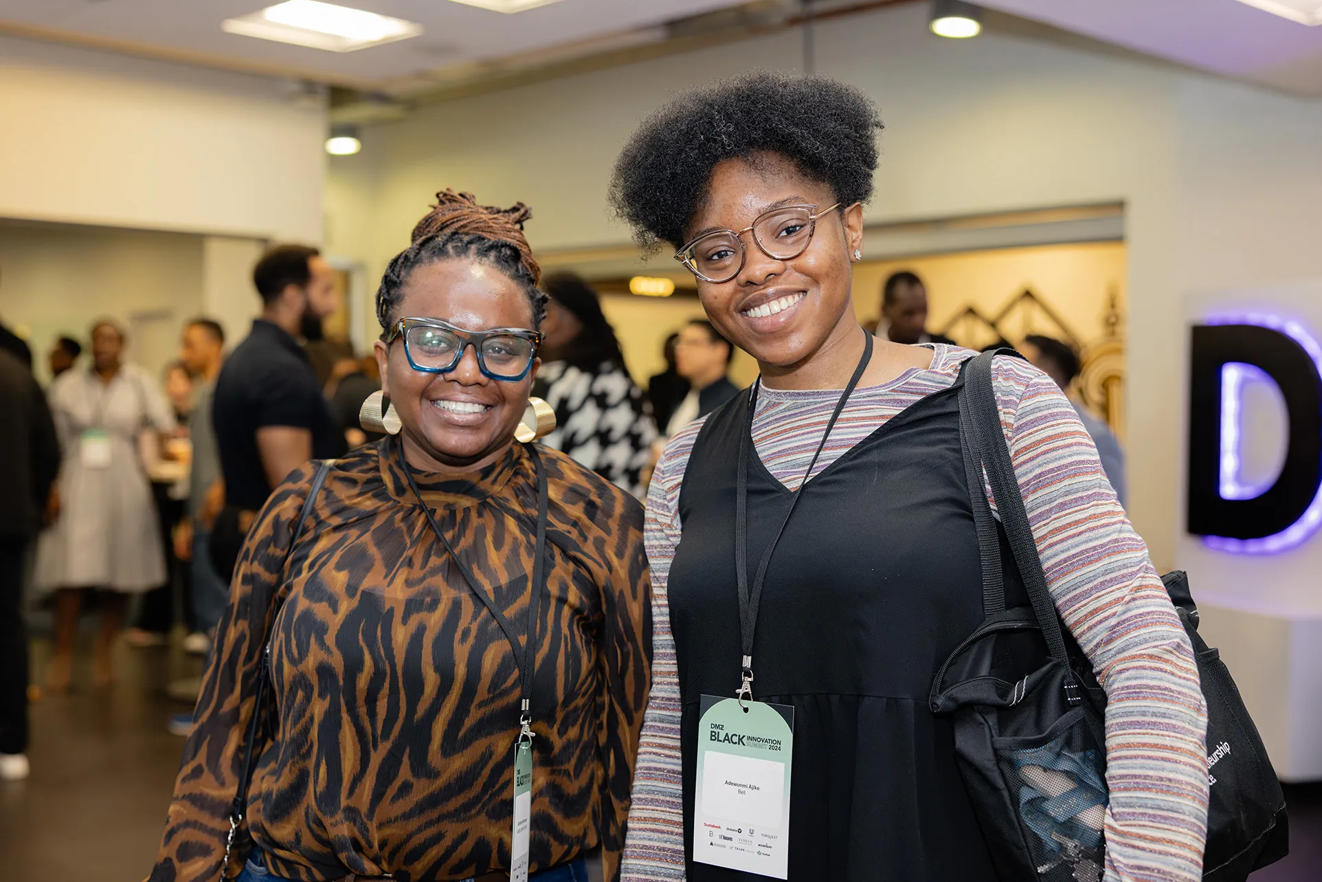 Two smiling Black women attendees at DMZ’s Black Innovation Summit 2025, celebrating Black excellence in tech through trailblazing conversations and powerful community-building.
