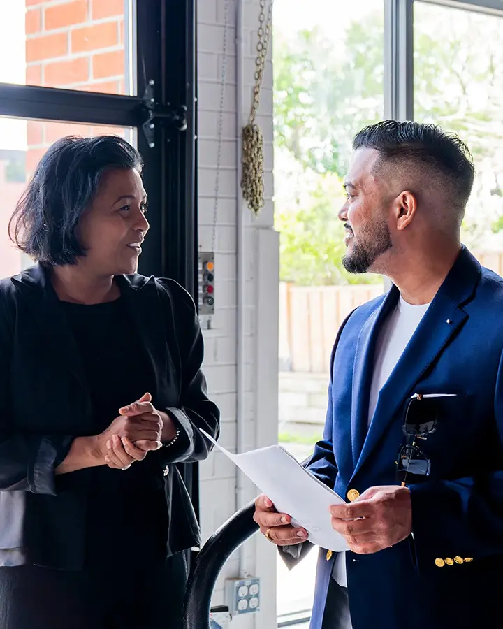 DMZ startup founder speaking with DMZ staff inside innovation hub, discussing business strategy and startup support.