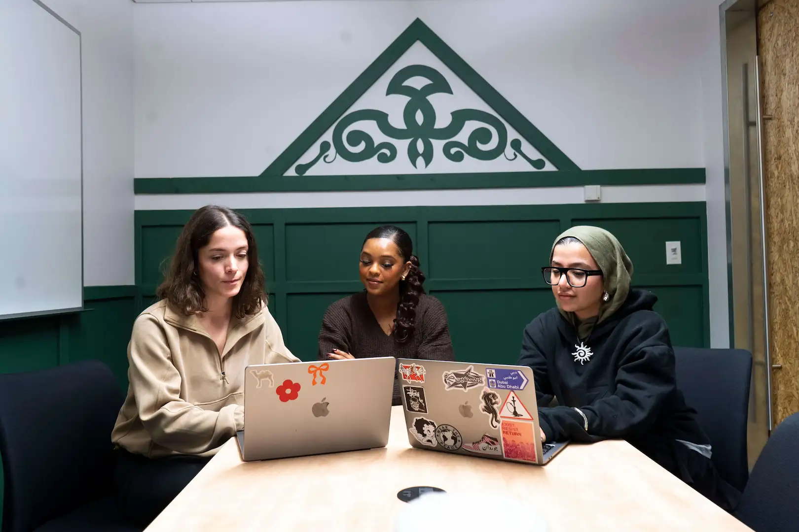 Diverse group of professionals collaborating at DMZ CoWork, fostering an inclusive community.