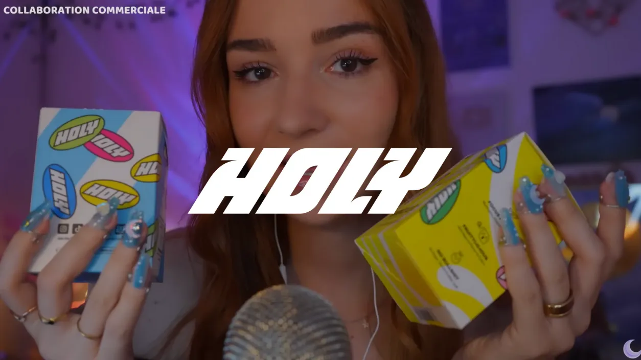 Femme tenant deux boîtes colorées marquées Holy, avec le texte HOLY en blanc au centre de l'image et la mention 'Collaboration commerciale' en haut à gauche.