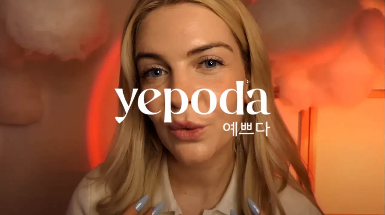 Une femme blonde avec un fond orange et des nuages flous, avec le mot yepoda en texte blanc superposé.