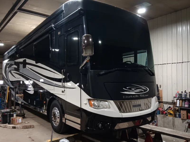 Newmar Dutch Star motorhome in a repair shop for winter RV maintenance, preparing for Iowa's freezing temperatures.