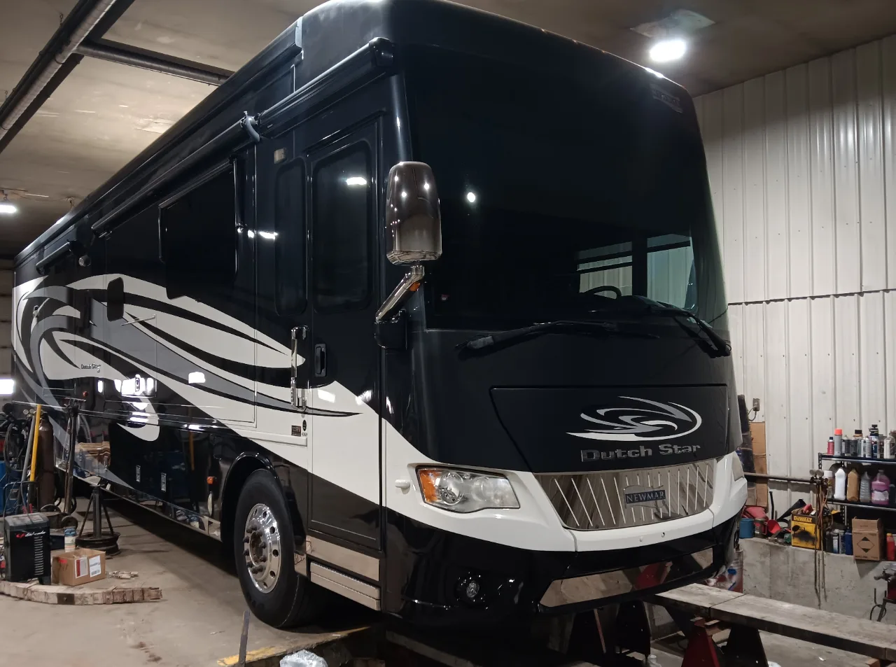 Newmar Dutch Star motorhome in a repair shop for winter RV maintenance, preparing for Iowa's freezing temperatures.