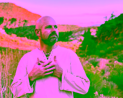 Man standing in a red rock desert landscape with hands over heart, wearing a natural linen shirt, embodying ancestral healing, mindfulness, and spiritual connection to nature.