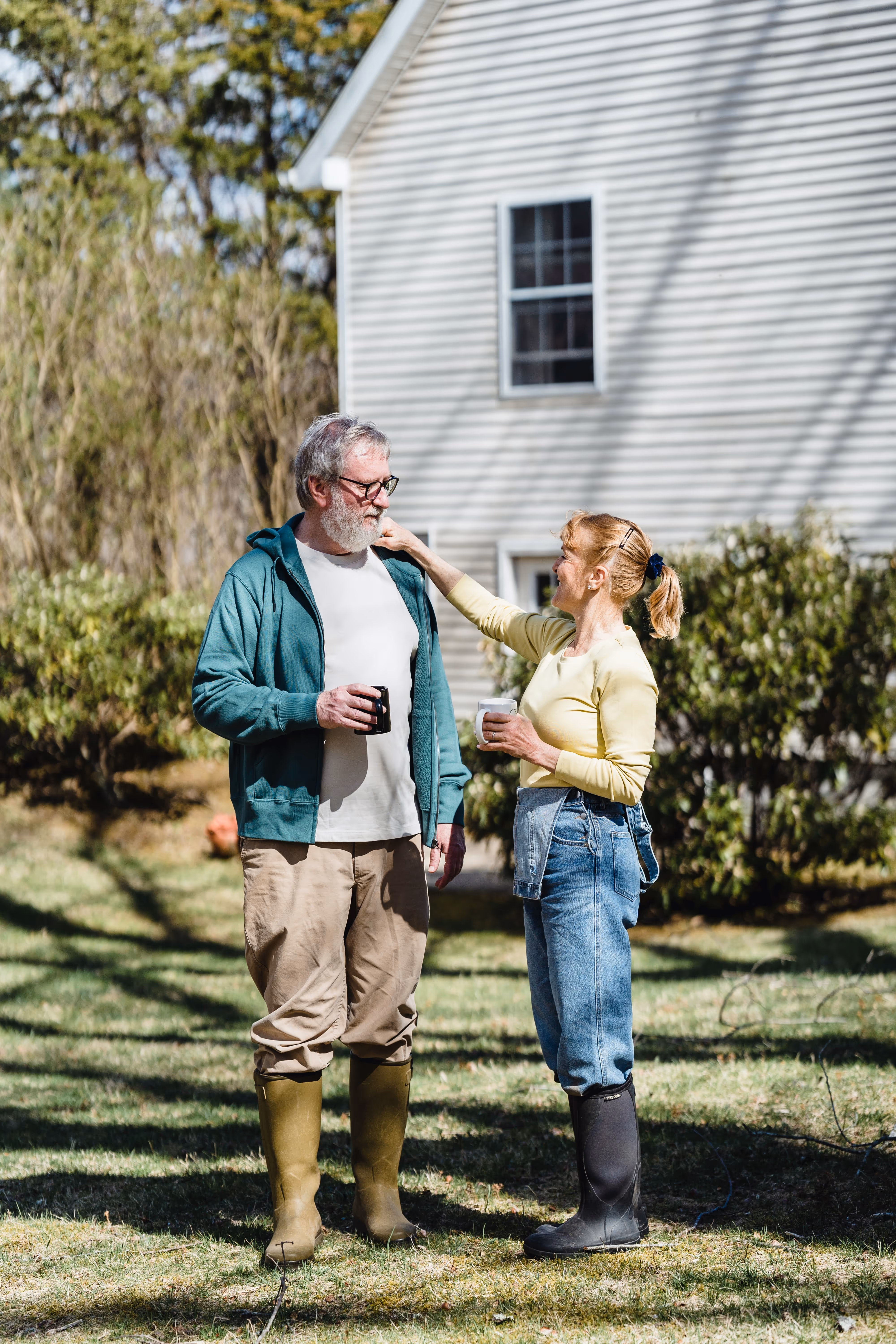 A man and woman embracing in their front yard