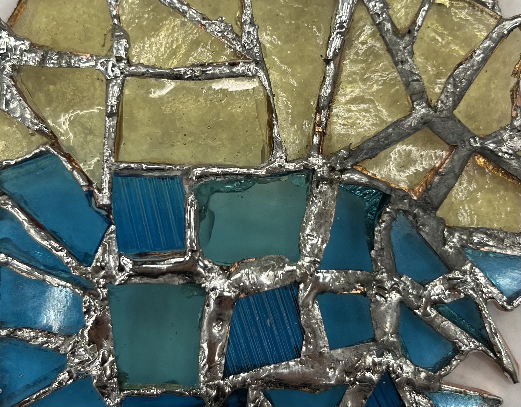 Soldered yellow and blue glass pieces.