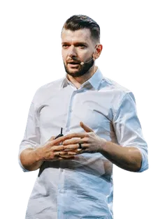 A speaker in a white shirt is presenting on stage, gesturing with hands while engaged in discussion.