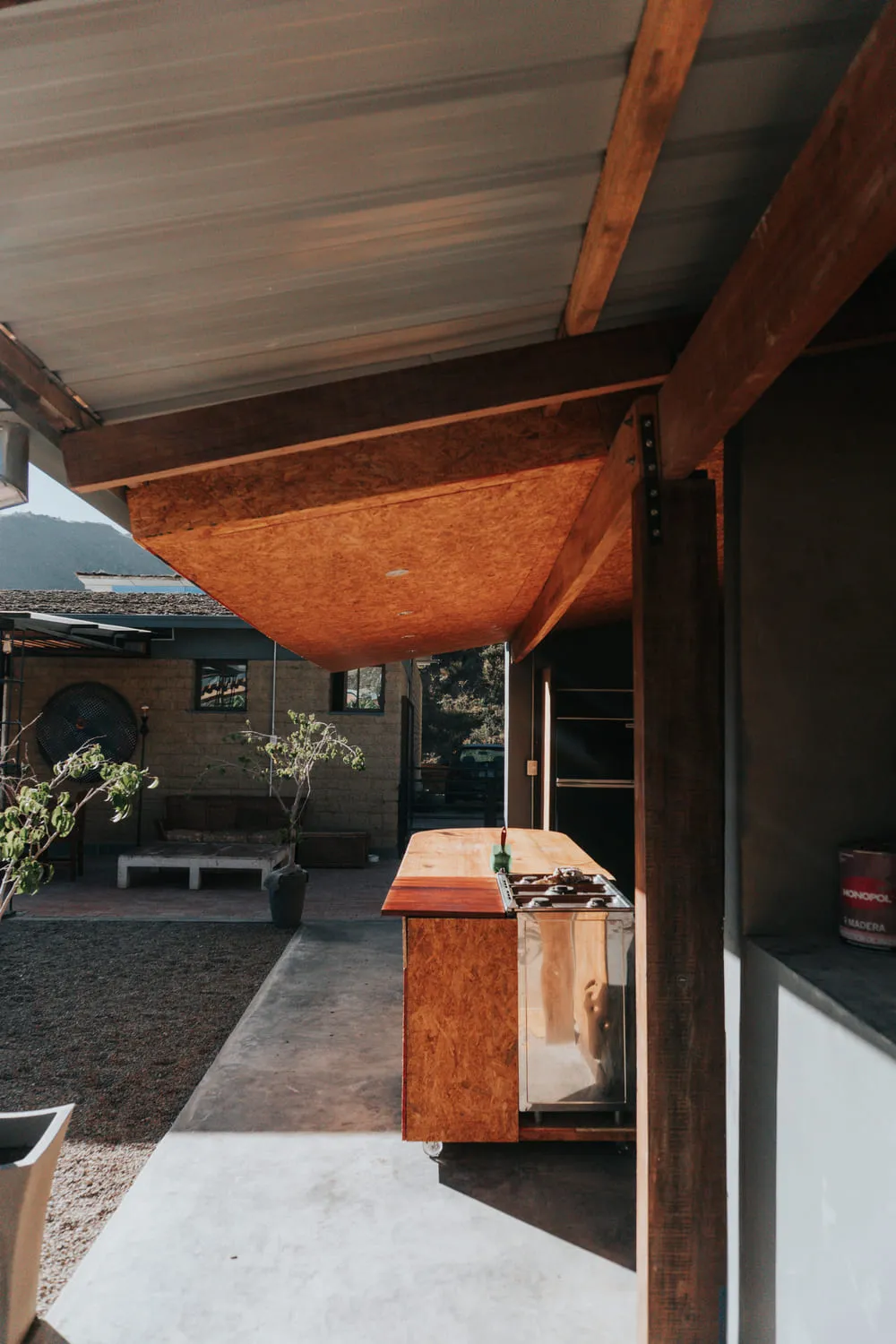 Terraza con mesón de madera y toldo, con la montaña de fondo.