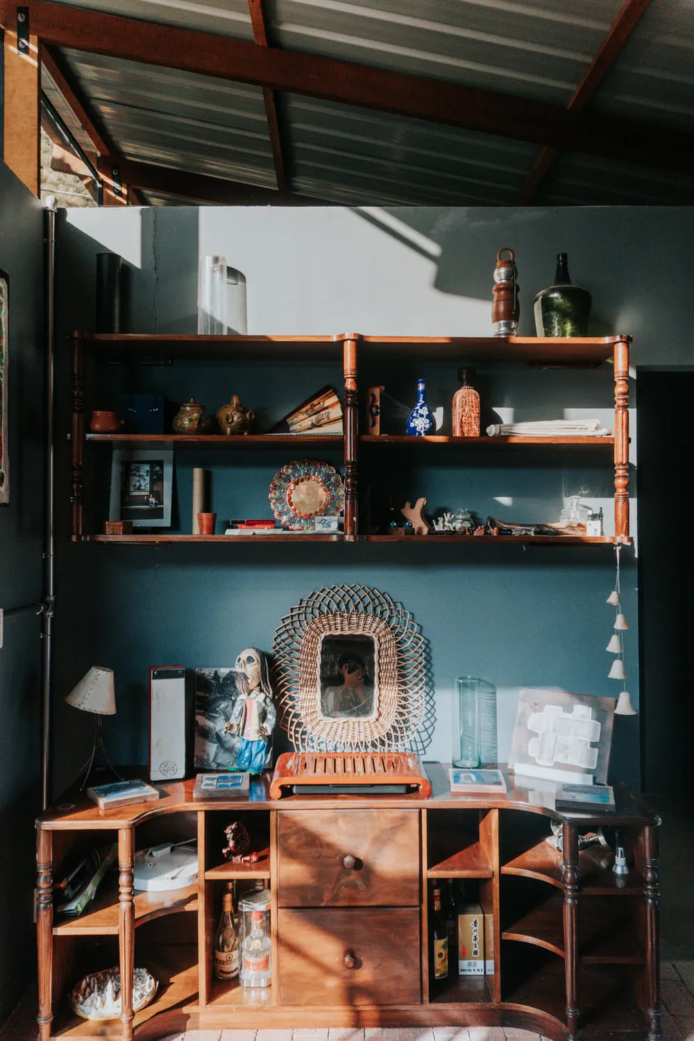 Repisas con objetos, un espejo y un escritorio de madera.