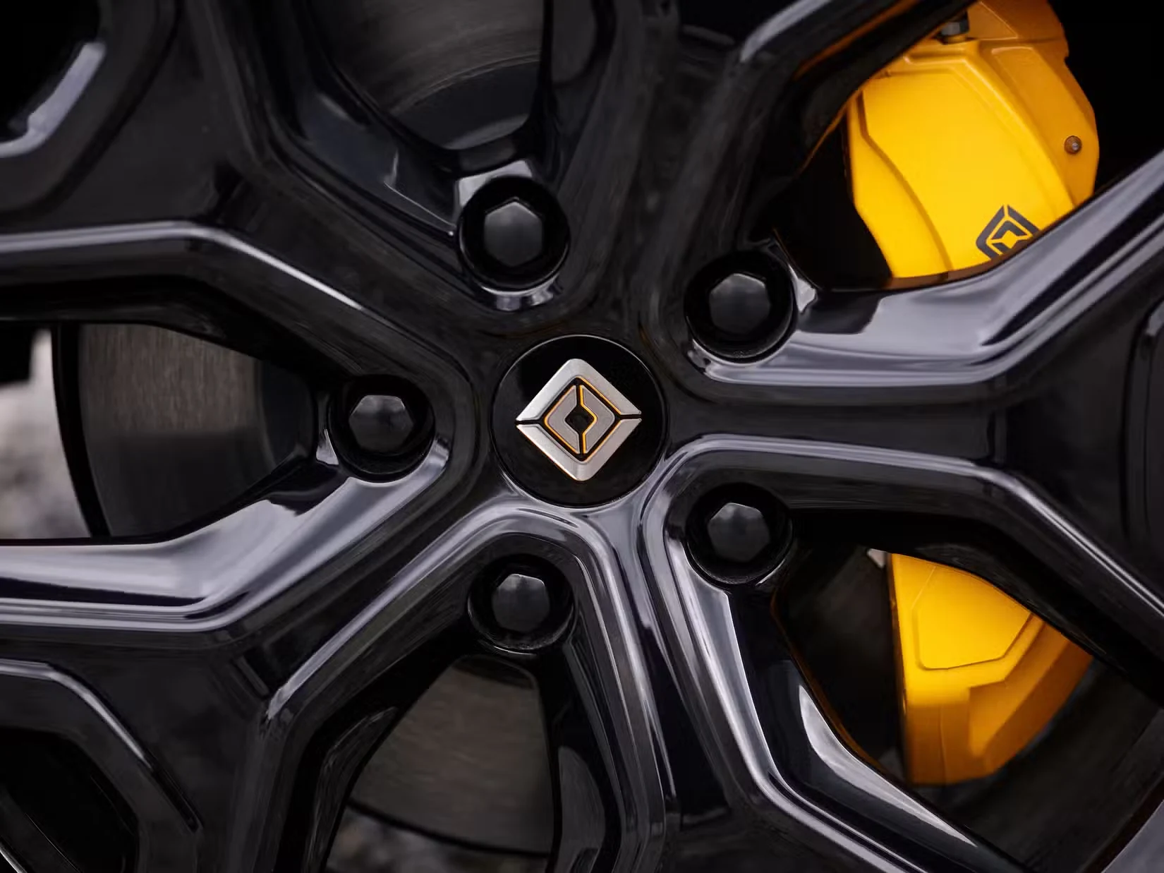 A black Rivian wheel, its brake calipers finished in Accent yellow