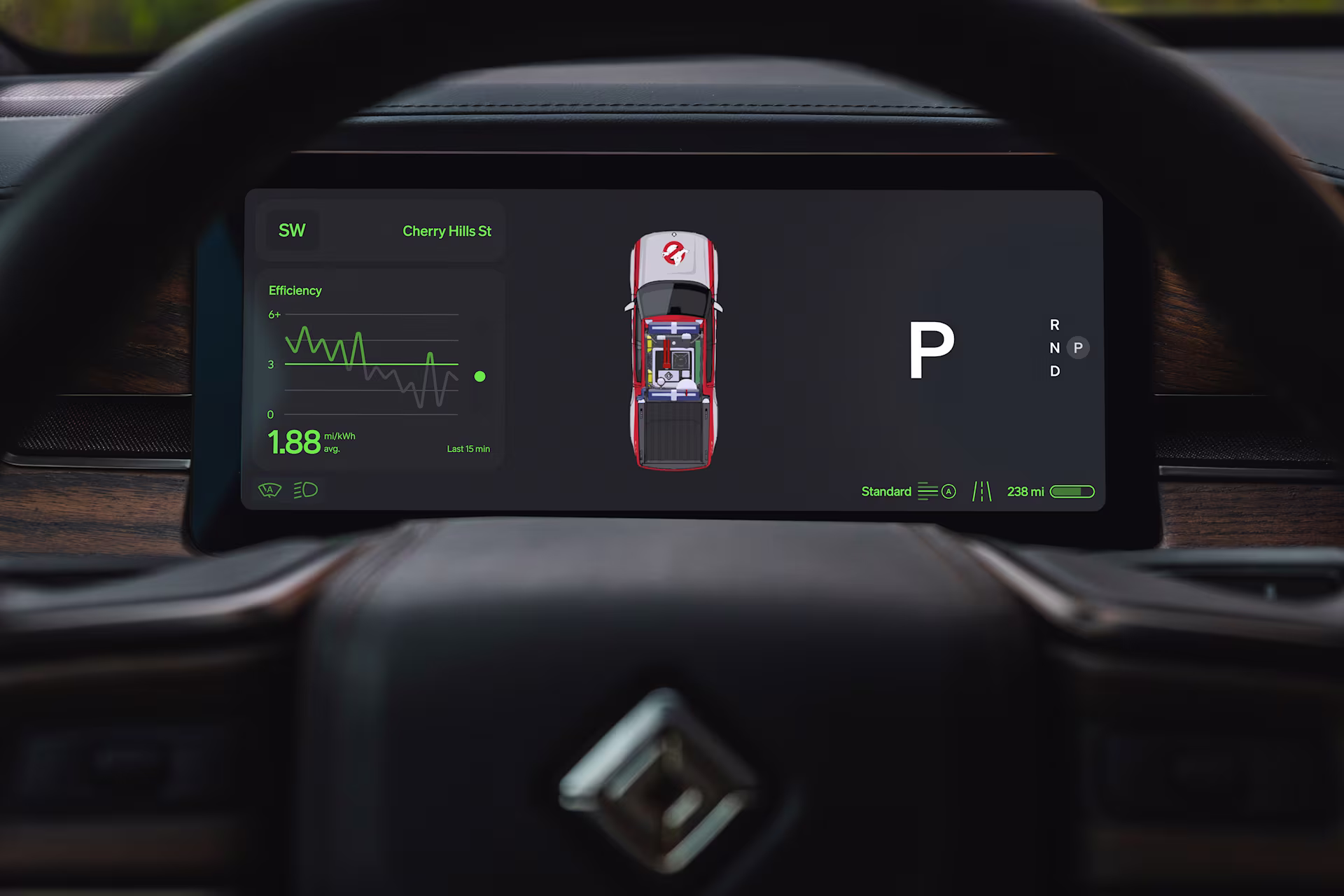The driver display in park: an efficiency graph, a top-down R1S in livery and a large P, in green on black.