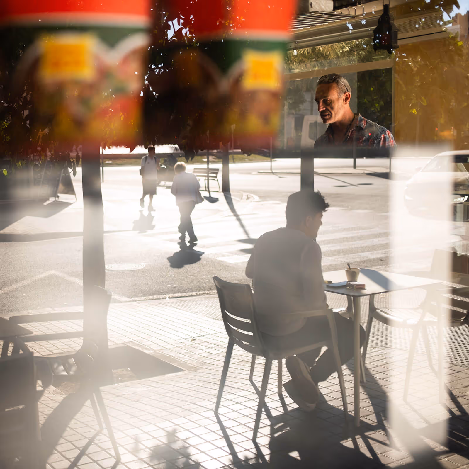 Glass reflection of someone sitting at a cafe