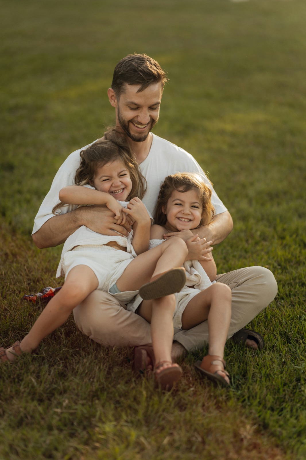 Young family embrace over snacks whilst sitting on a couch