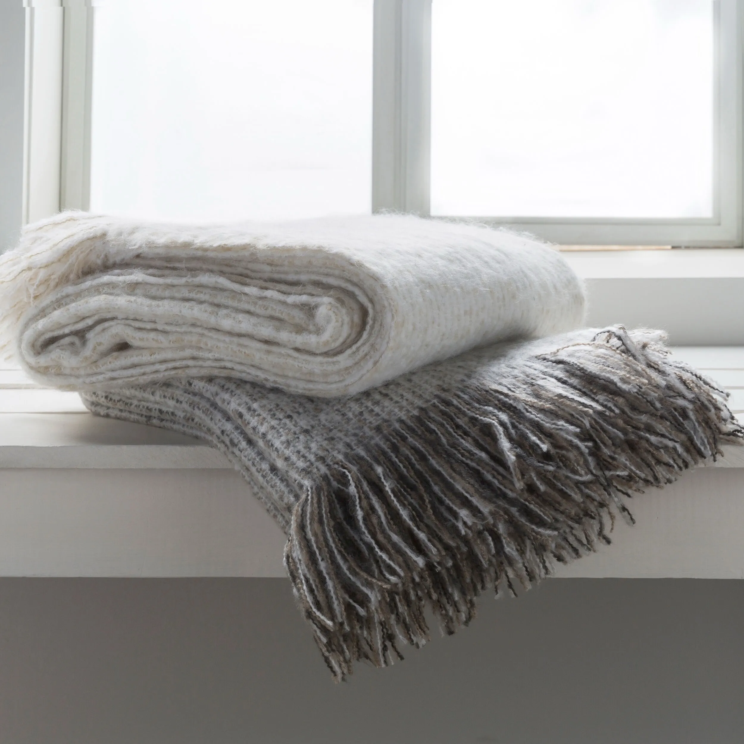 Grey throw blanket sitting on white shelf