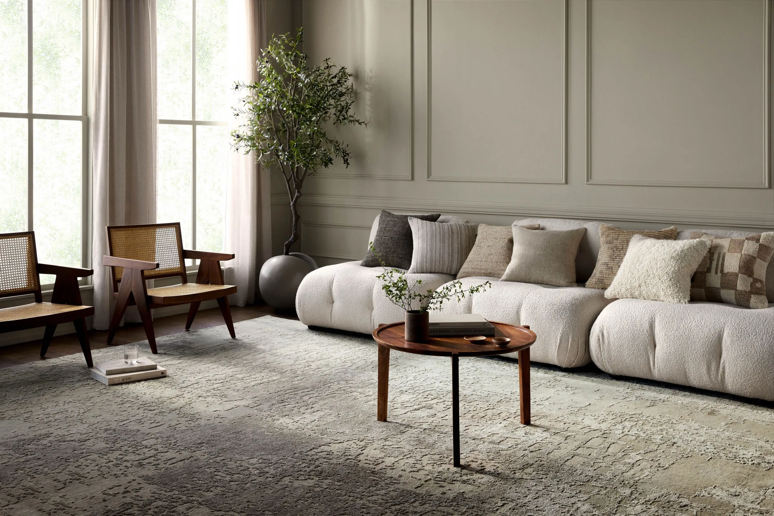 Long beige sectional sofa with 7 pillows and a small dark brown coffee table 