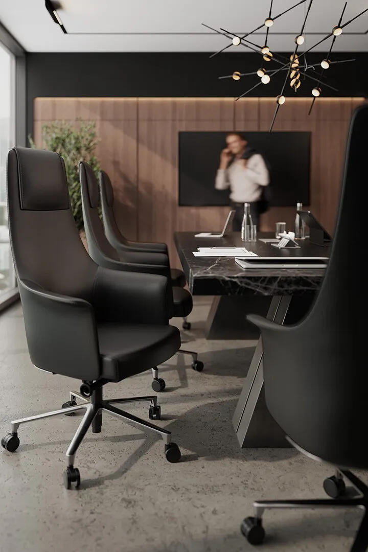 A BDI black office chair displayed in a office boardroom with an executive in the background