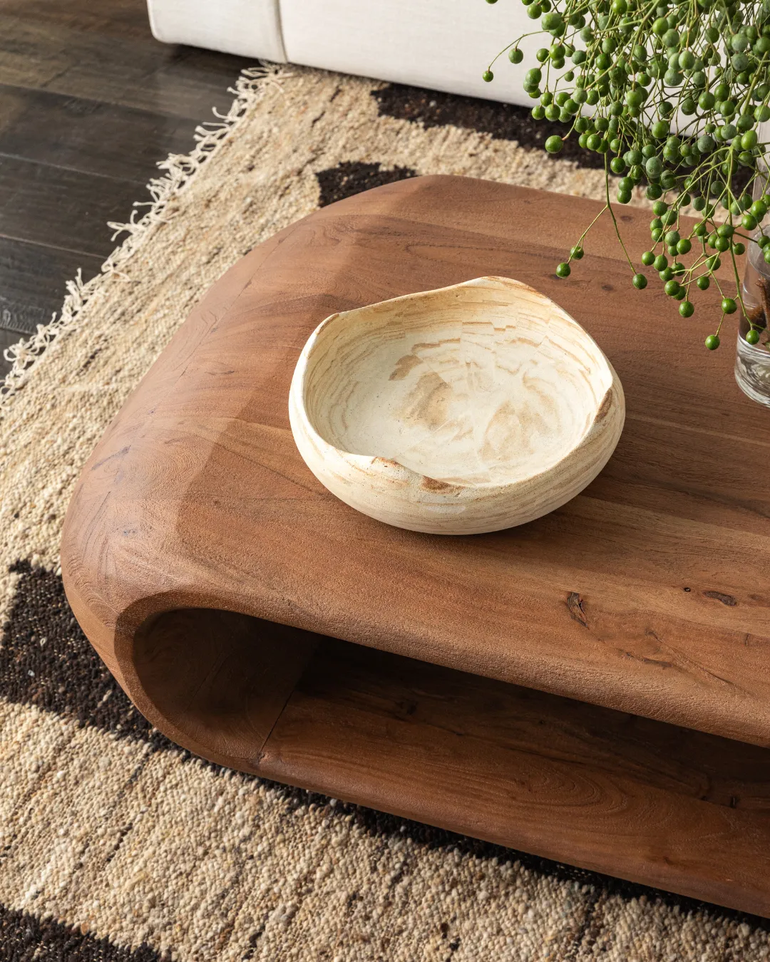 Wooden coffee table with light brown wooden bowl sitting on top