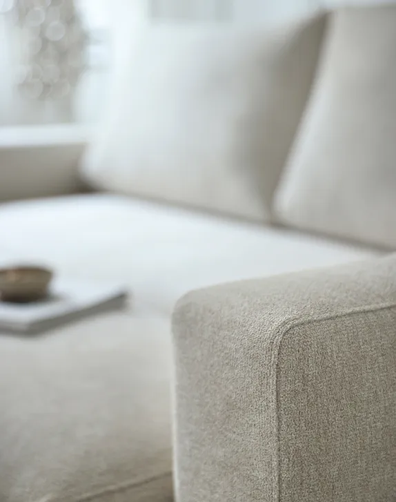 Close-up shot of the arm of a white sofa