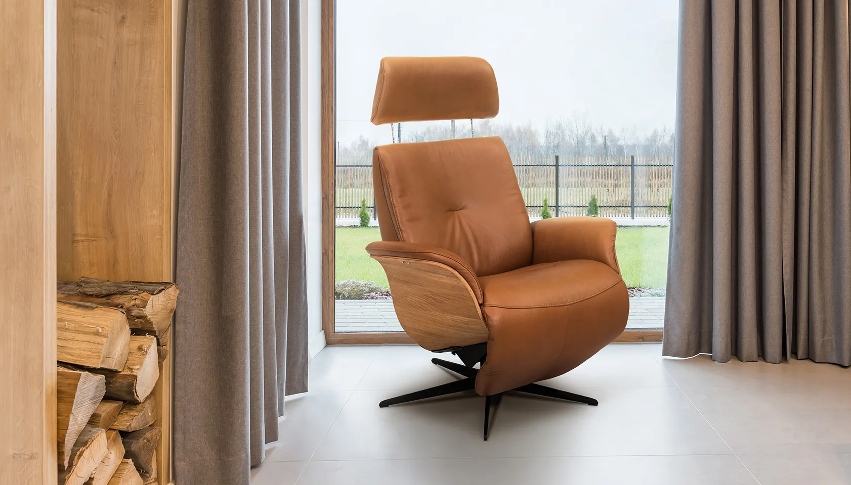 Hjort Knudsen brown leather recliner next to open window 