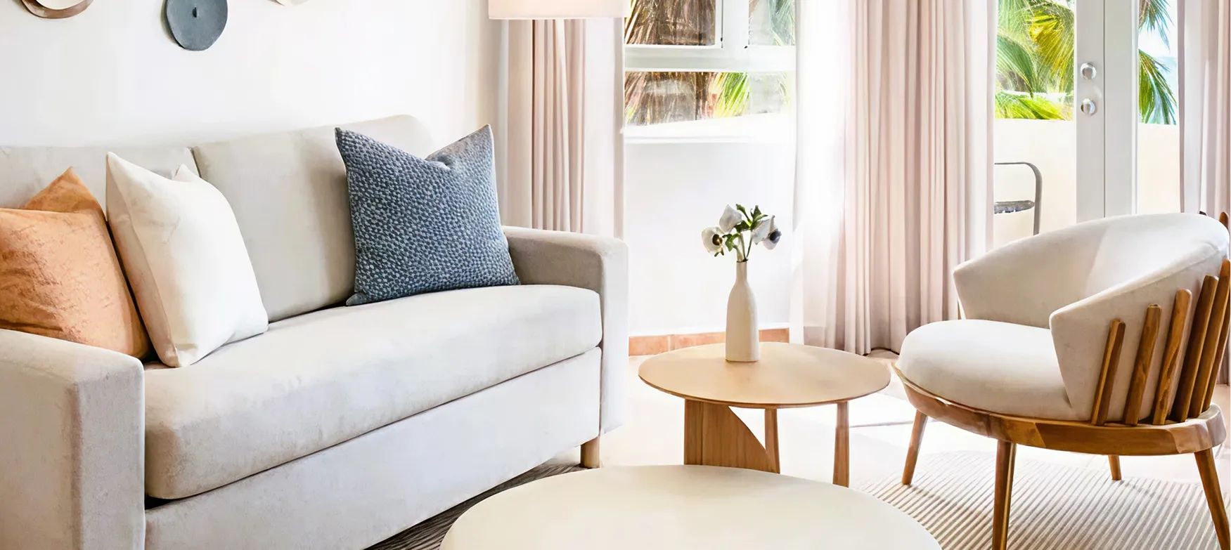 White sofa with blue pillow and white chair 