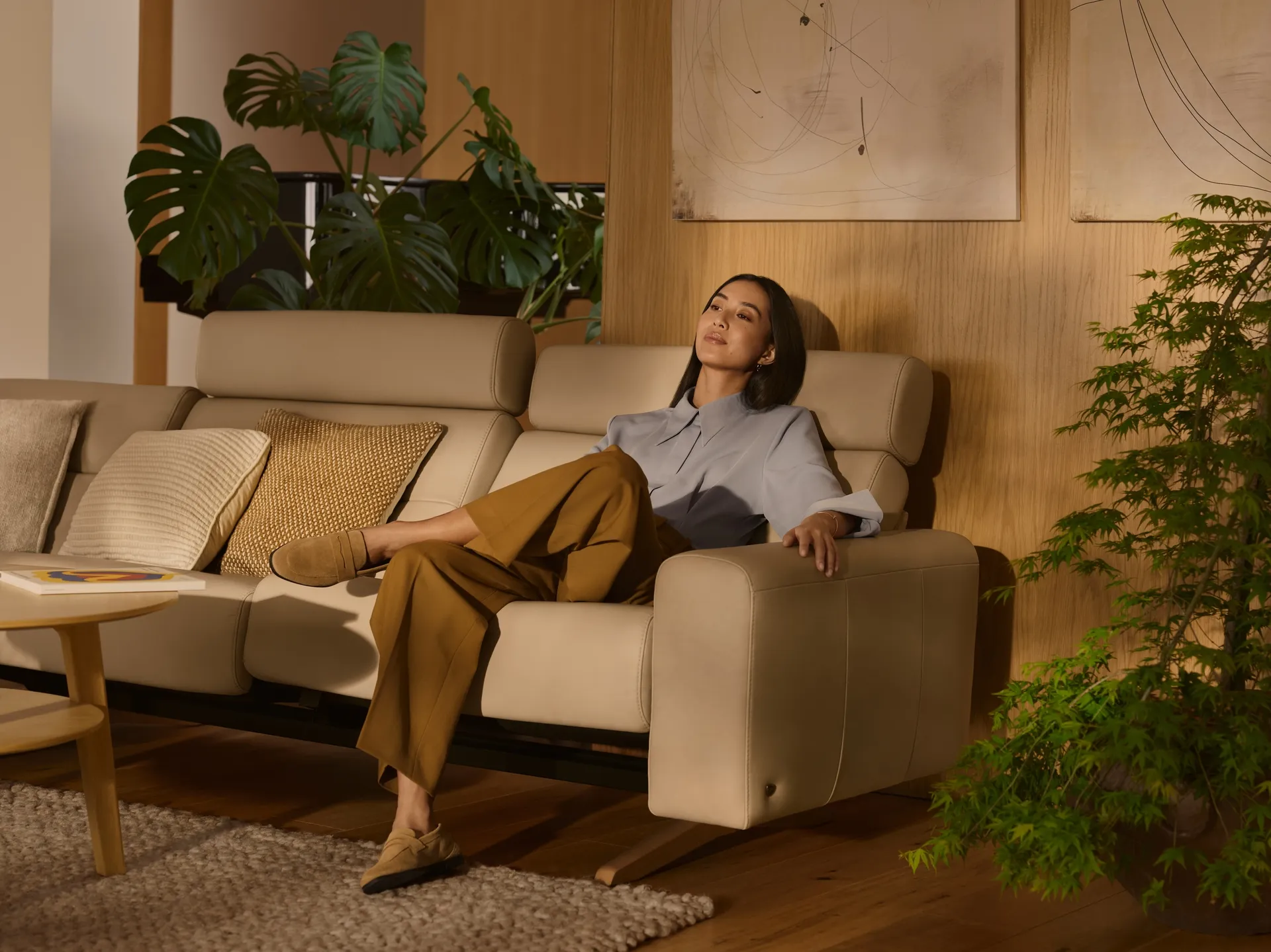 A woman sitting comfortably on a white sofa 