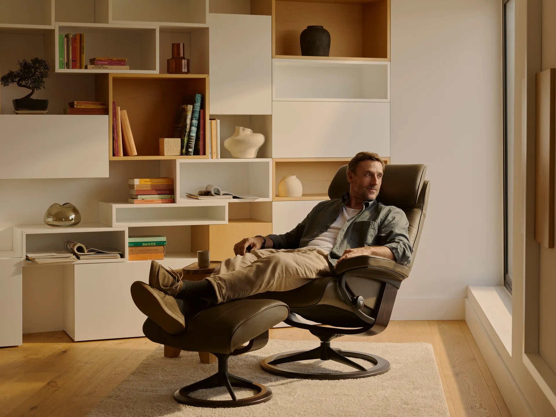 A Stressless Paul Signature Velaro recliner with a man sitting in it with his feet up relaxing