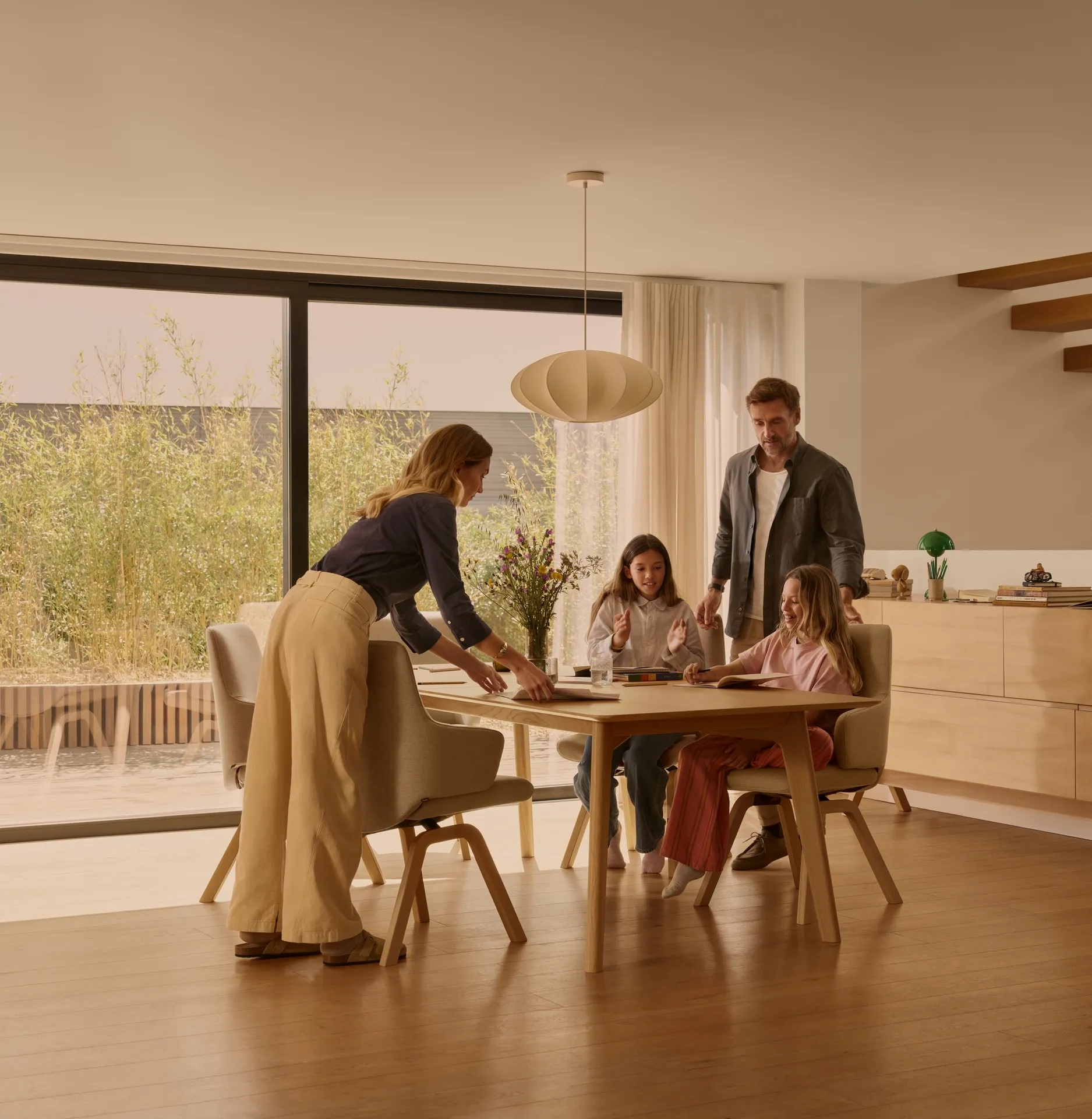 Family woman man and children gather around circular dining table 