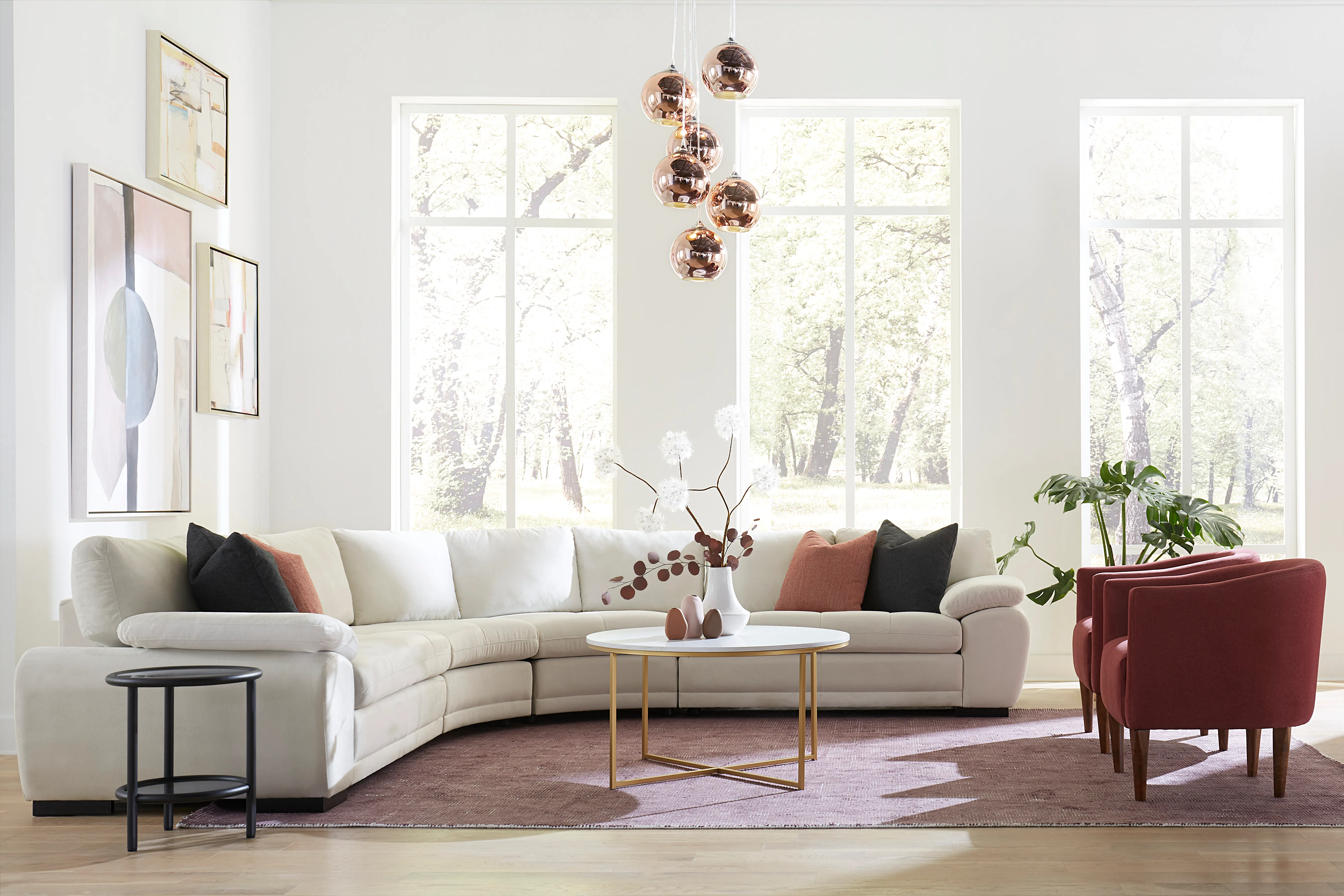 Large white sectional in living room with dark pink accent chair and four matching pillows 