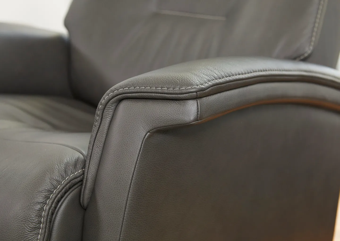 Close up shot of Fjords dark grey recliner arm showing leather fabric and stitching 
