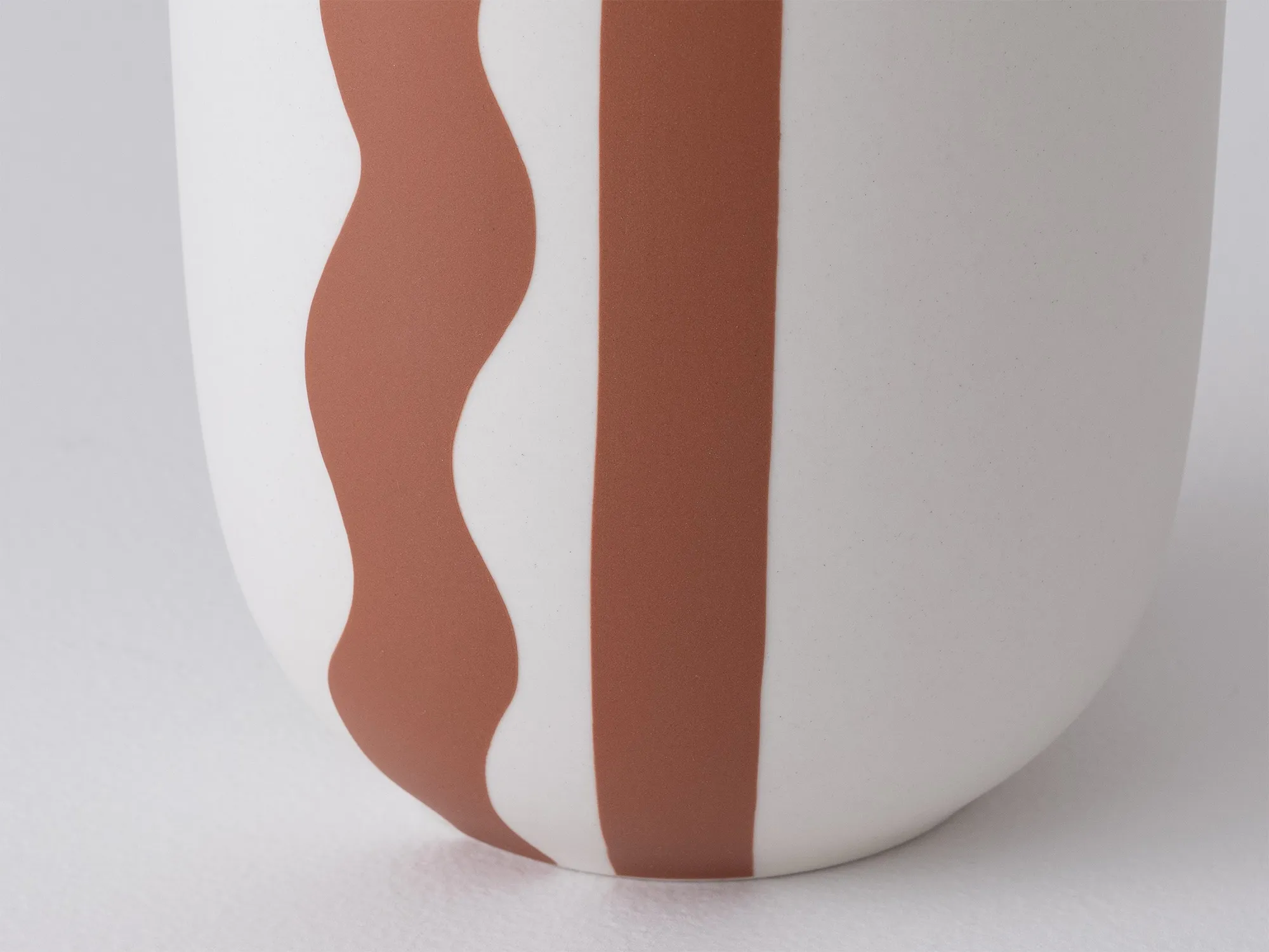 Close up of white vase with brown abstract design