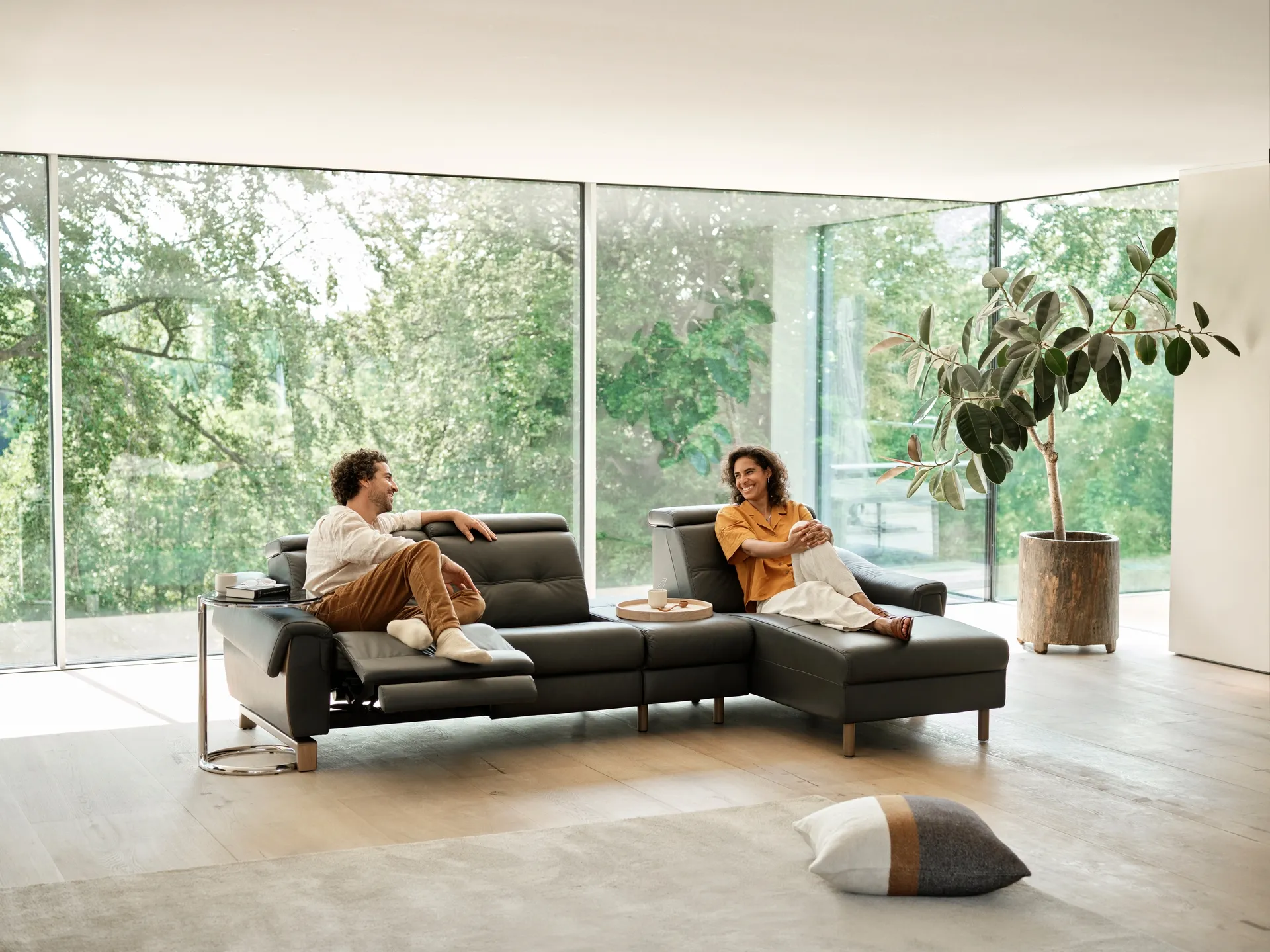 A couple sitting on a Stressless sofa smiling