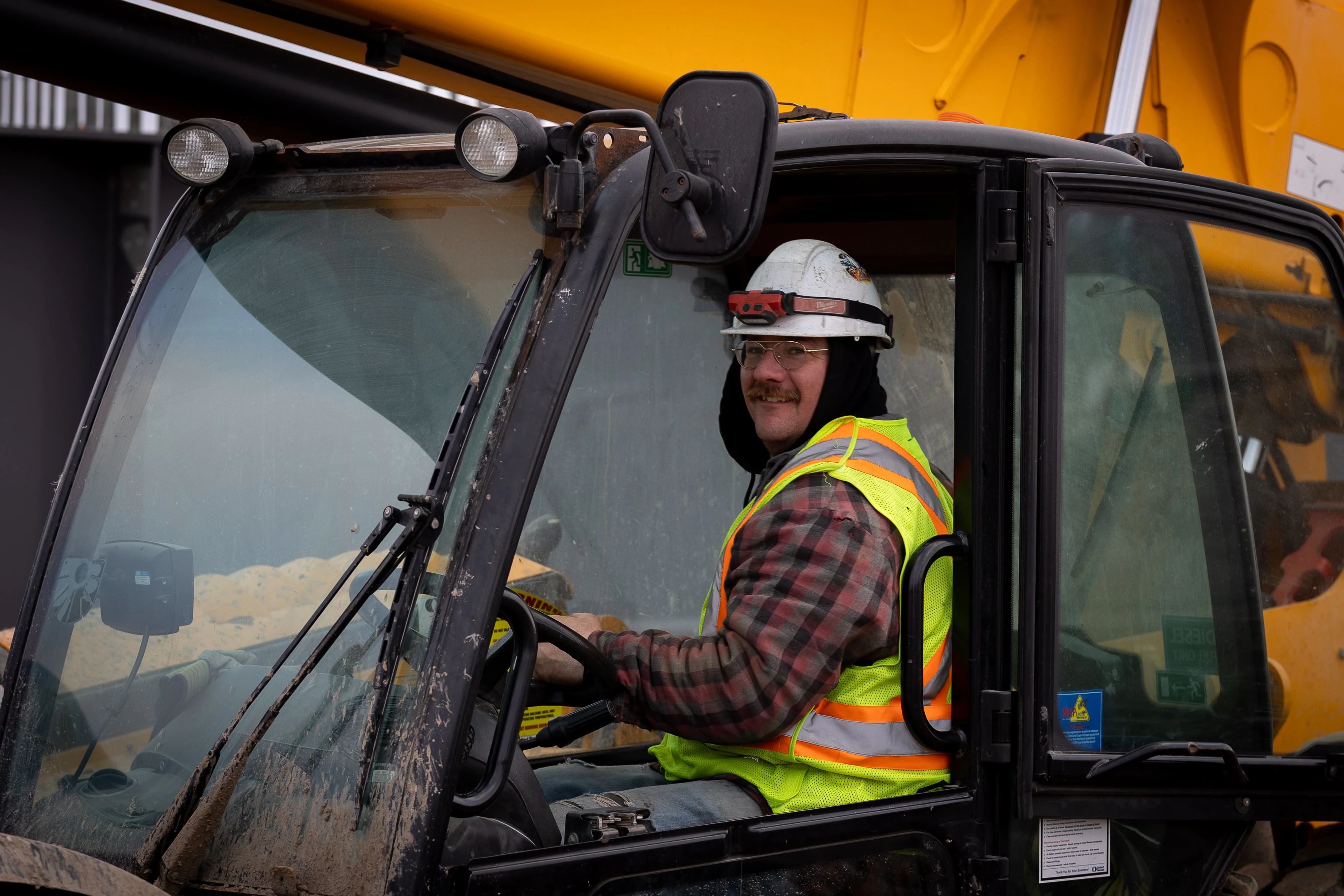 Construction equipment operator operating excavator on MD Steele commercial project in Winnipeg