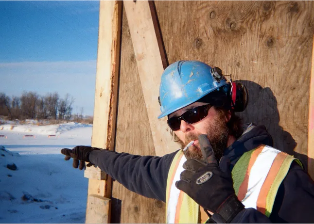 Construction carpenter measuring wood framing on residential building project in Edmonton