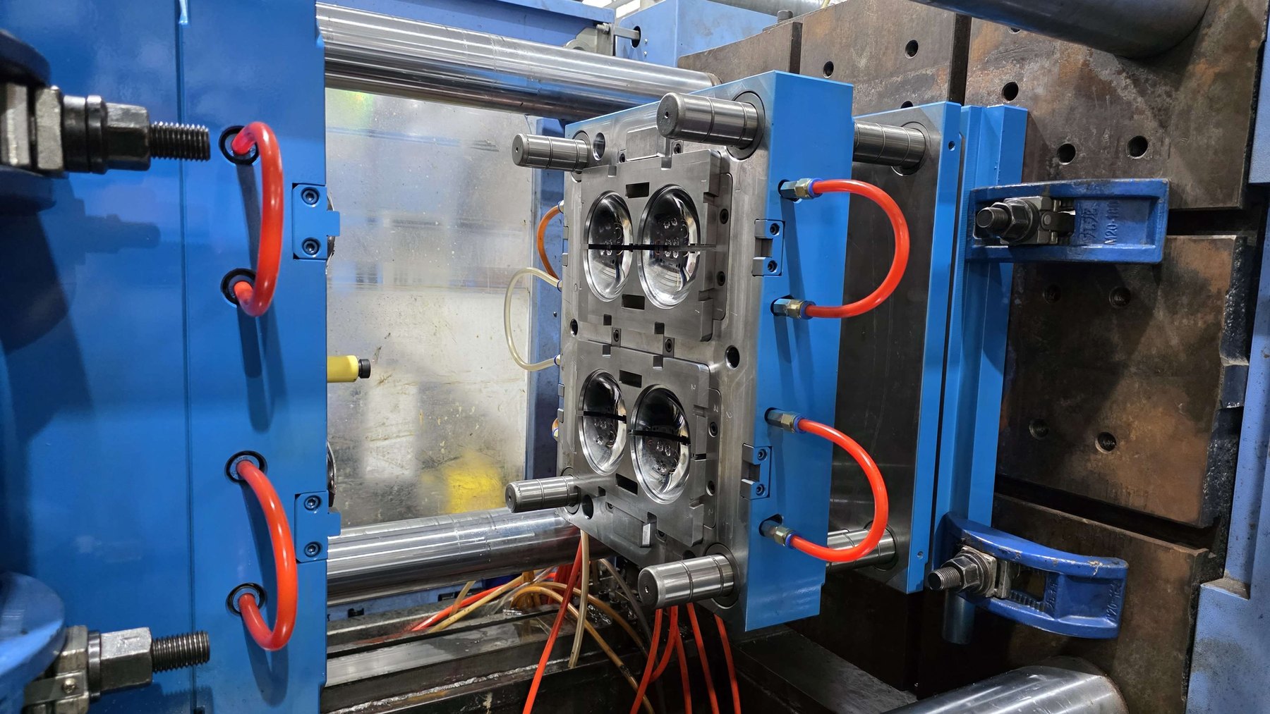 Four-cavity injection mold with mirror-polished cavities and cooling lines connected, mounted in a press at Jadewell's factory
