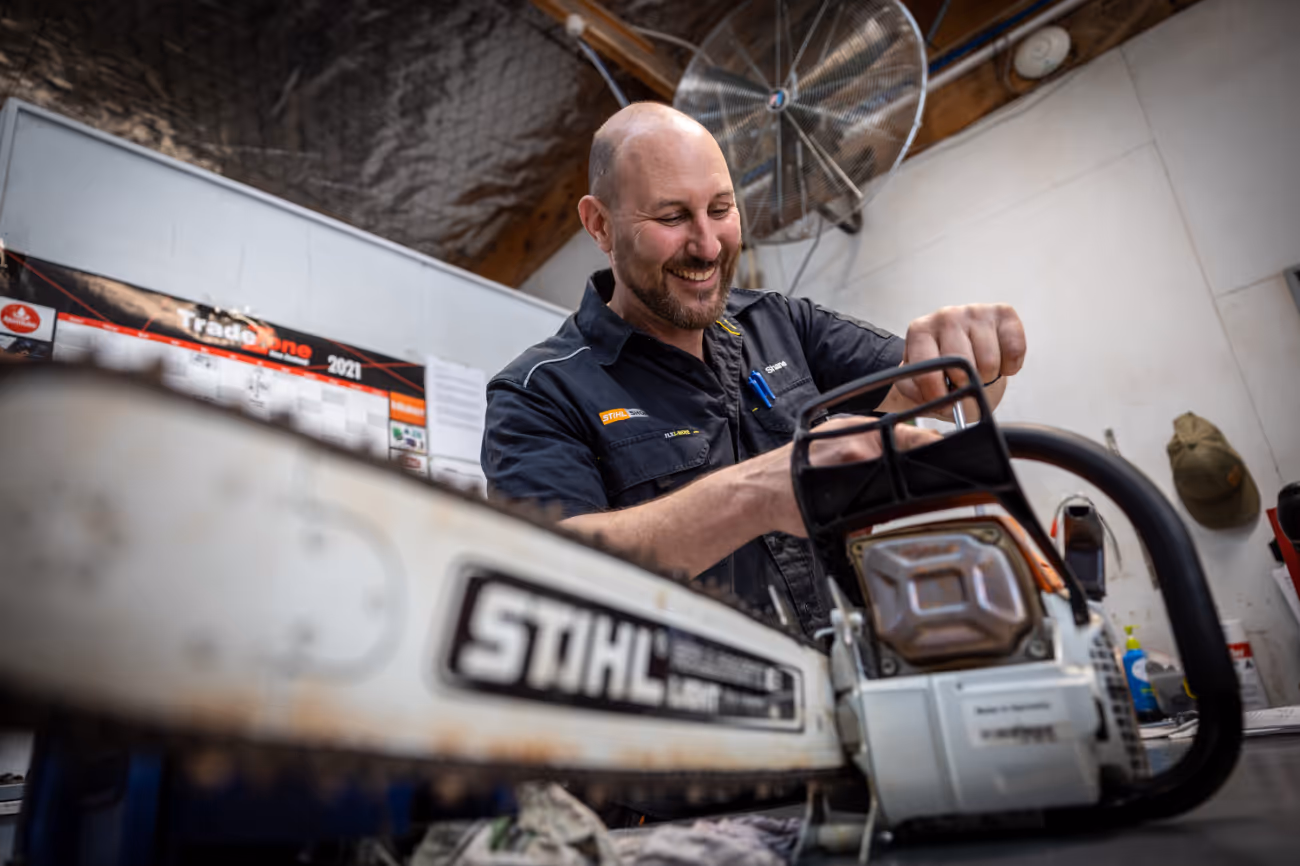 Man servicing chainsaw. 