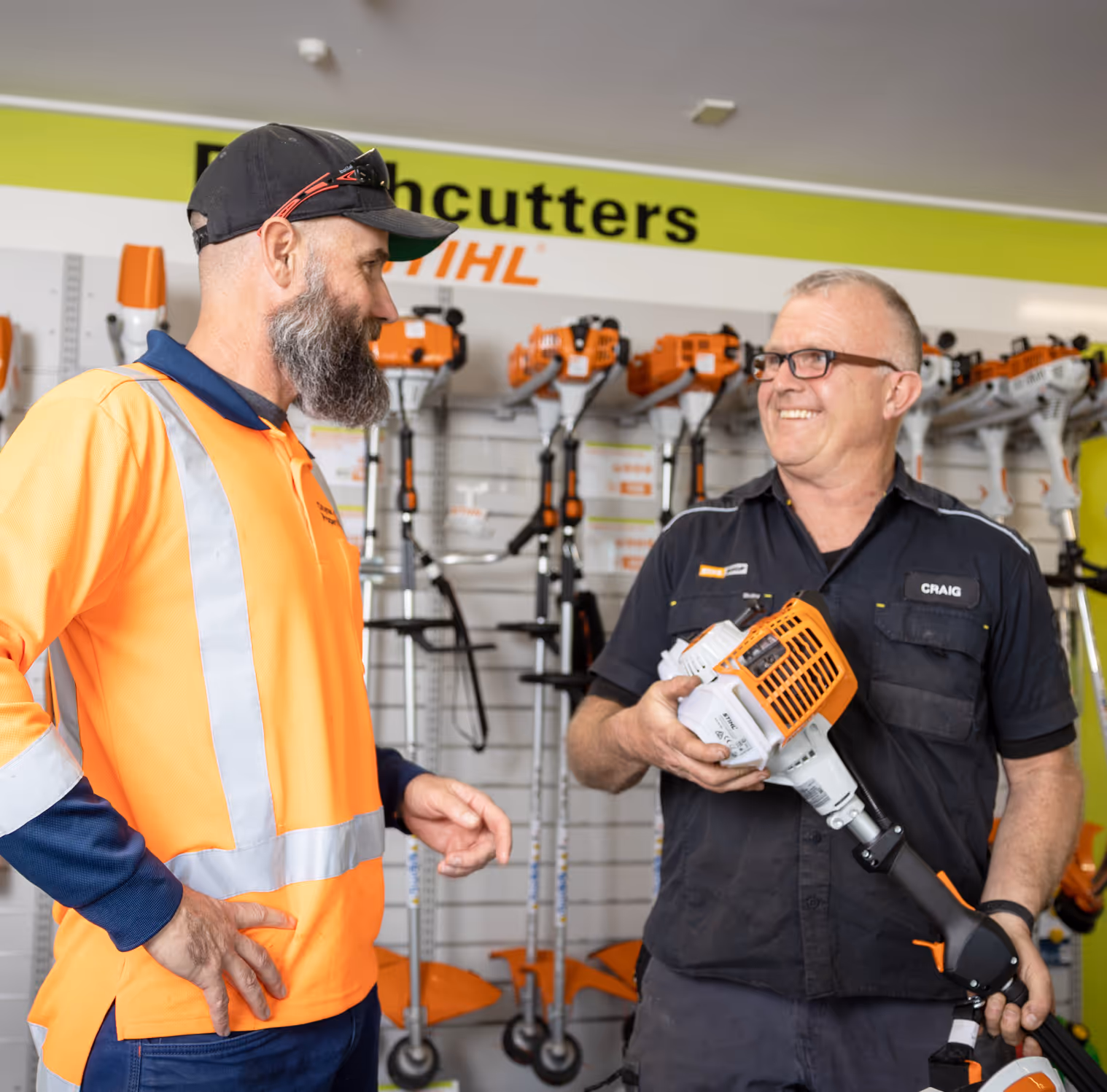 Two men talking about line trimmer. 
