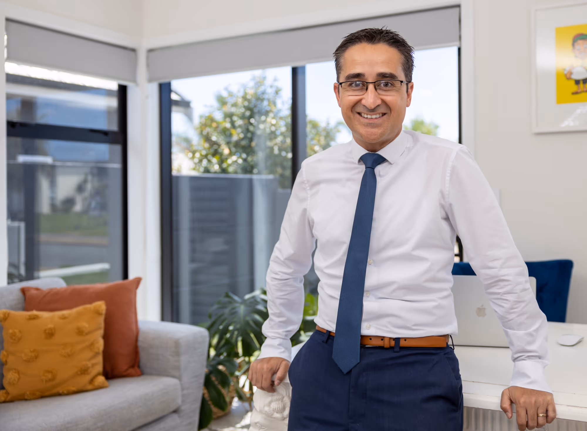 Man in tie standing in front of window. 