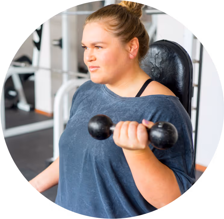 Woman in gym using weights. 