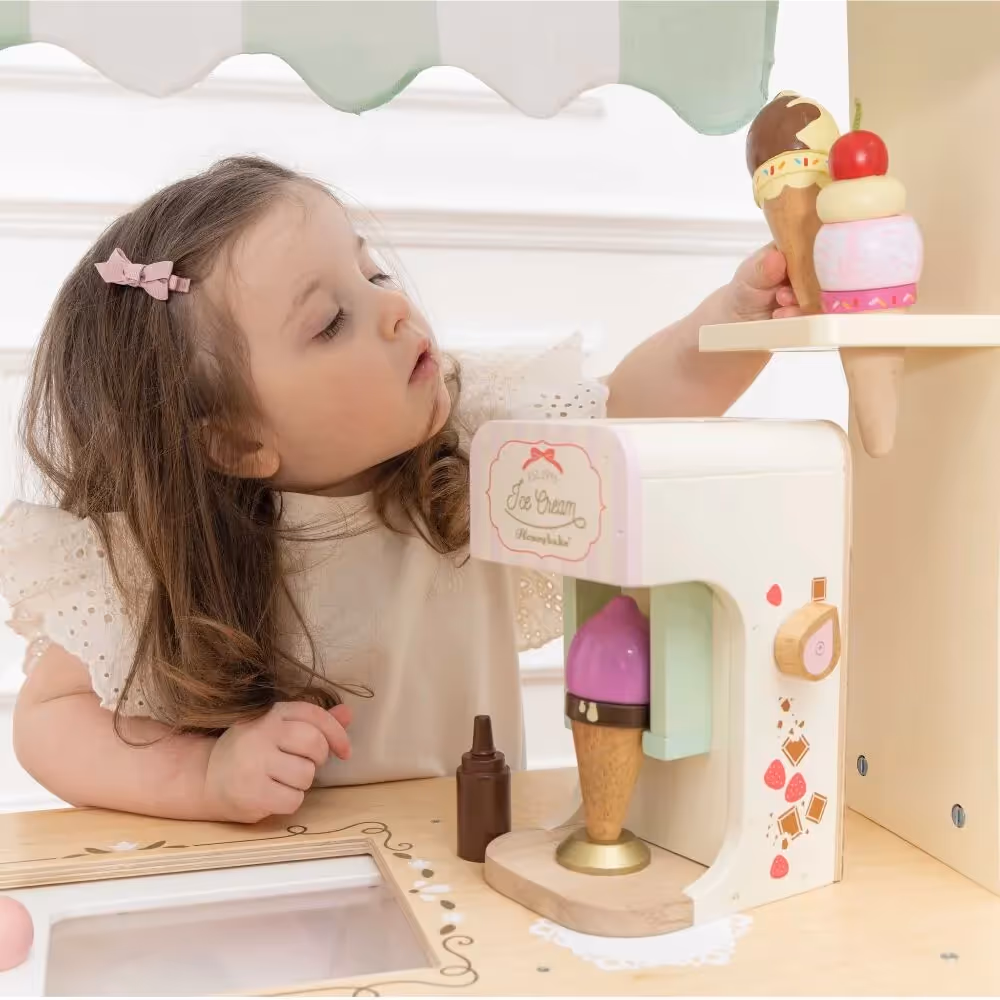 Young toddler playing with ice cream machine toy. 