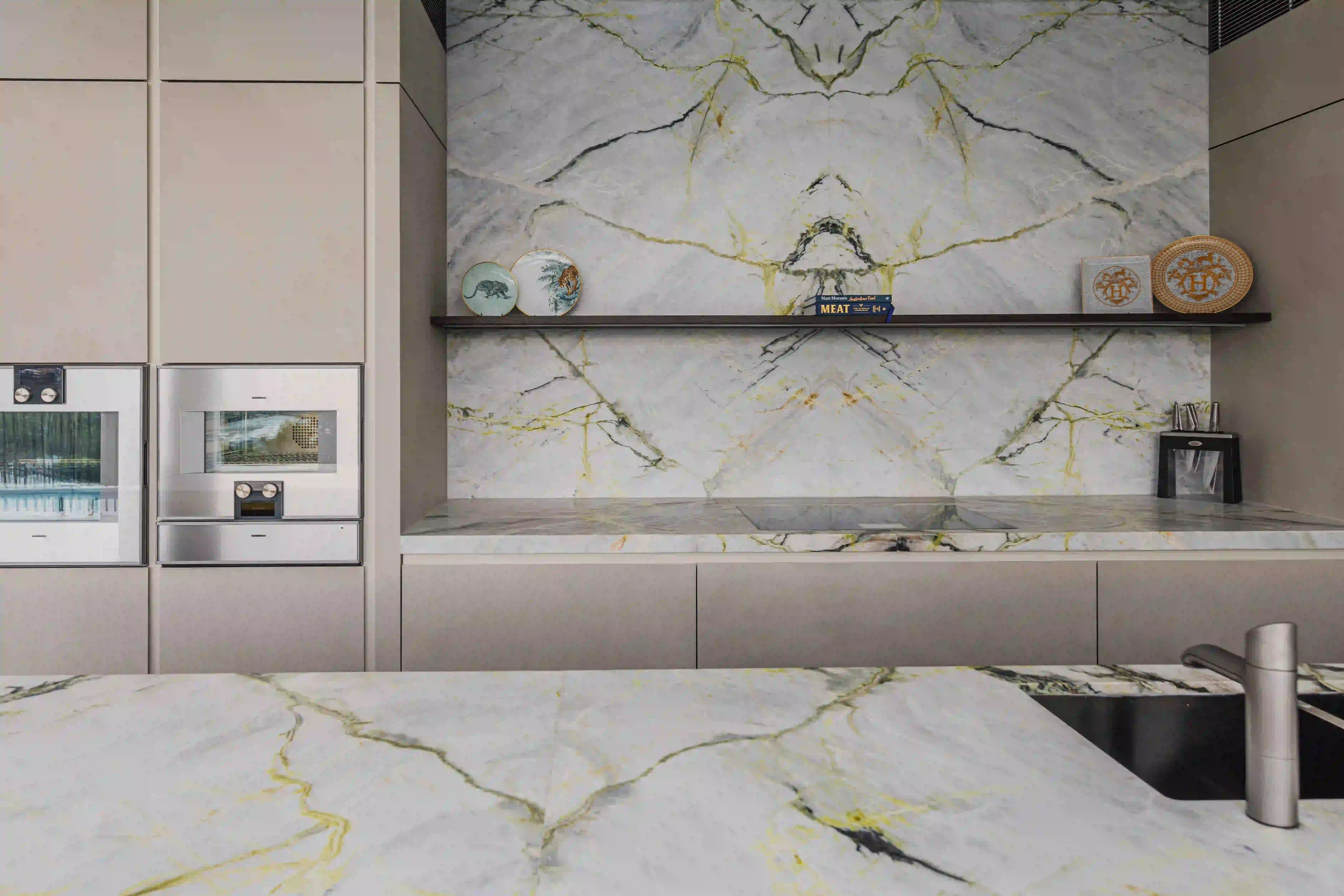 Kitchen featuring green, black and white marble benchtops and splashback.