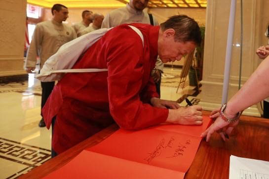 Dr. Weng  signs a paper
