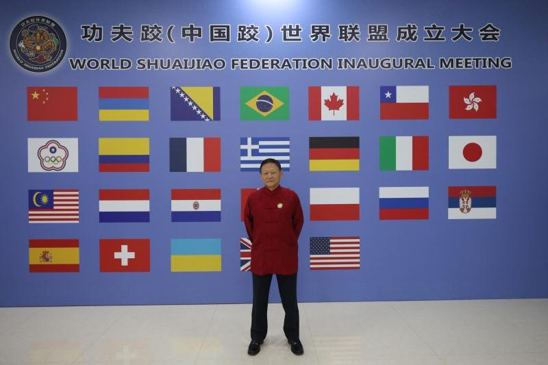 Dr. Weng standing in front of WSJF wall
