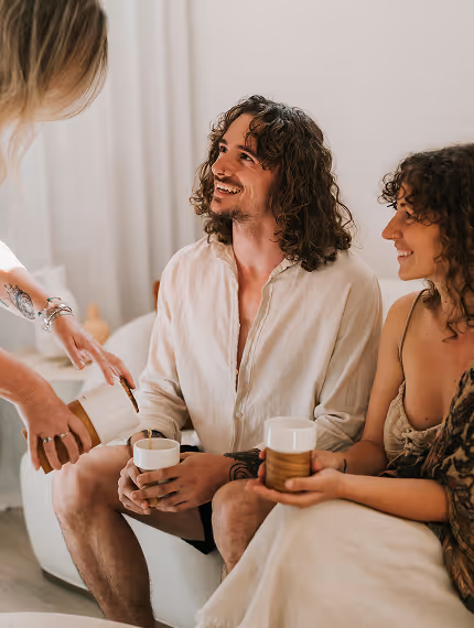 Couple being served tea on a couch