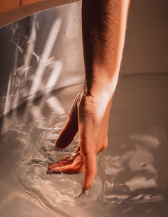 Hand gently touching bath water